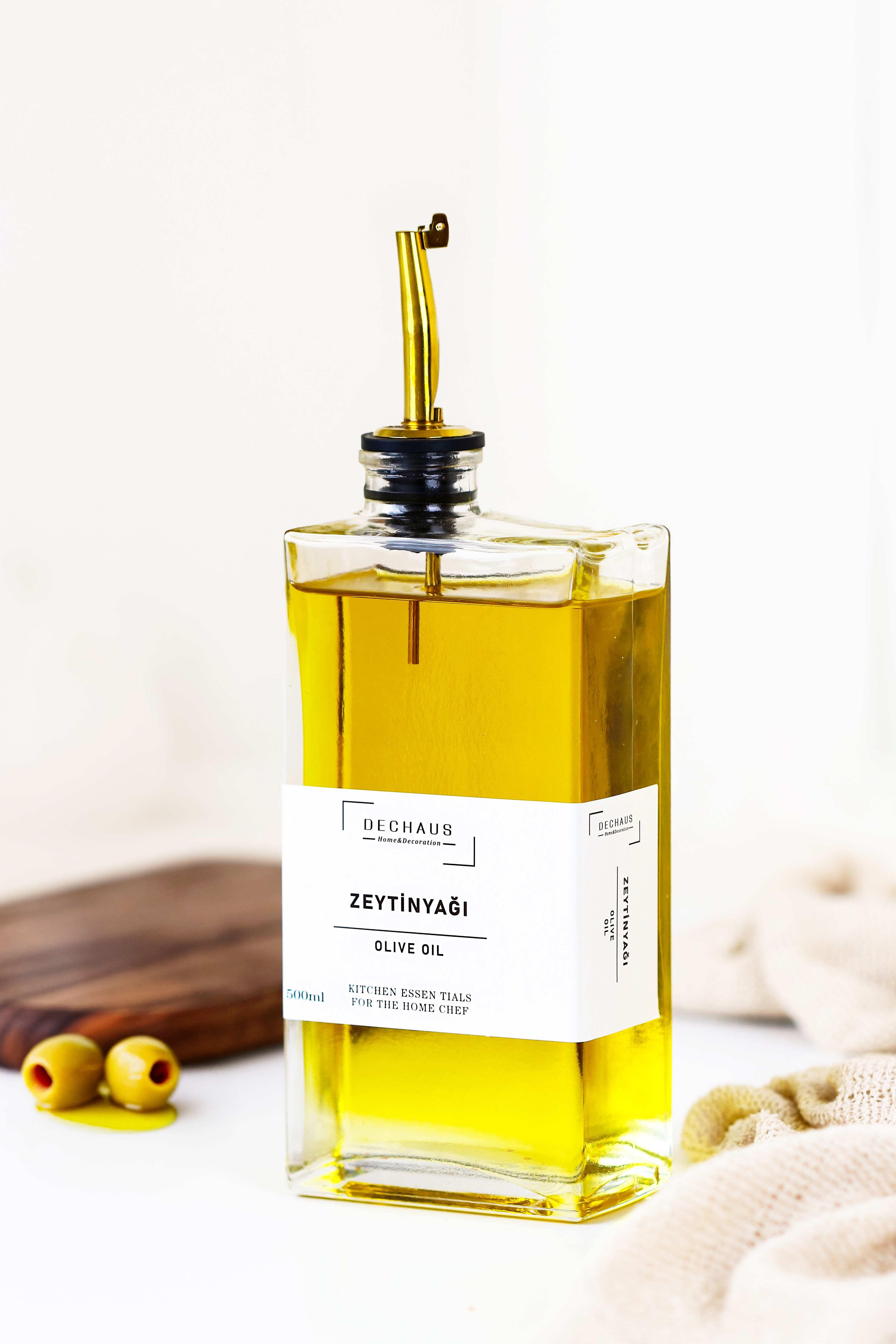Bottle of golden extra virgin olive oil with fresh olives