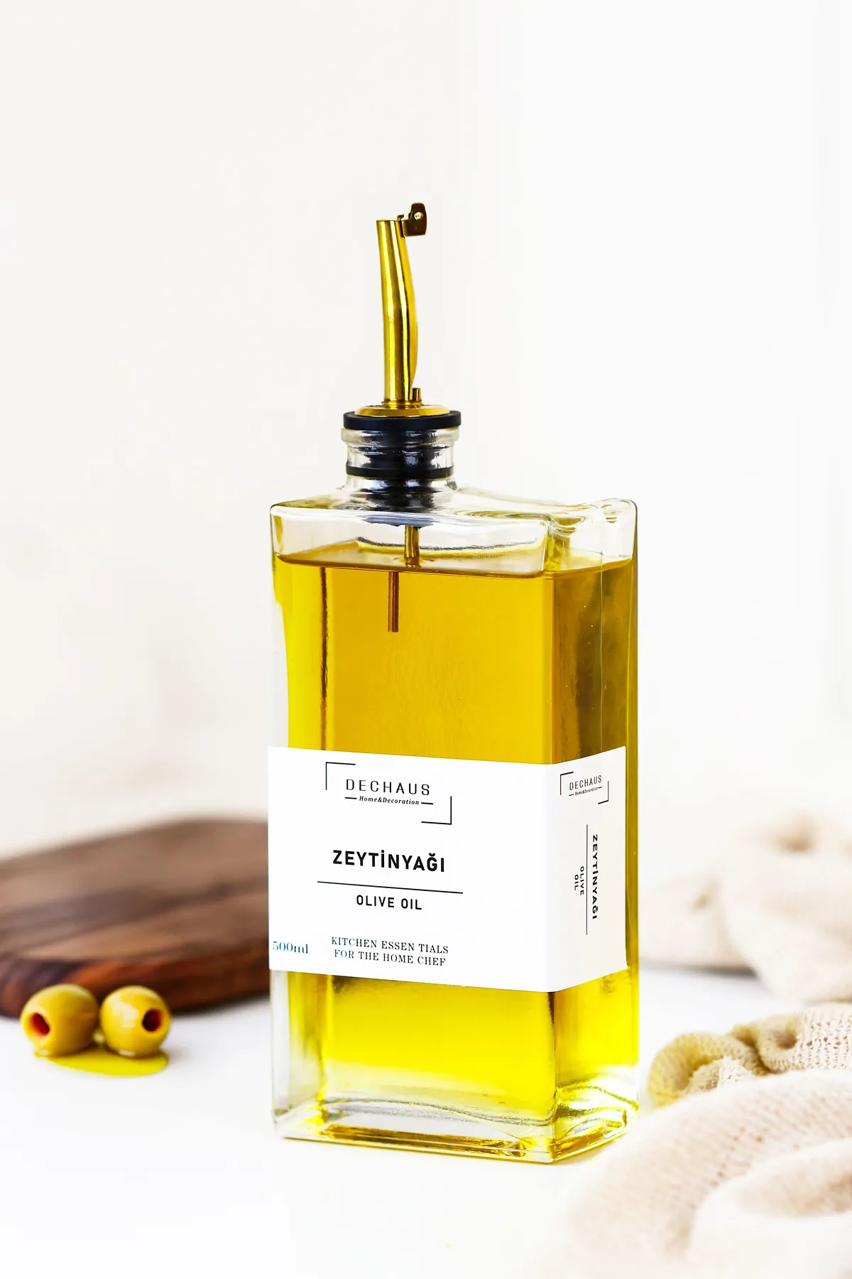 Bottle of golden extra virgin olive oil with fresh olives