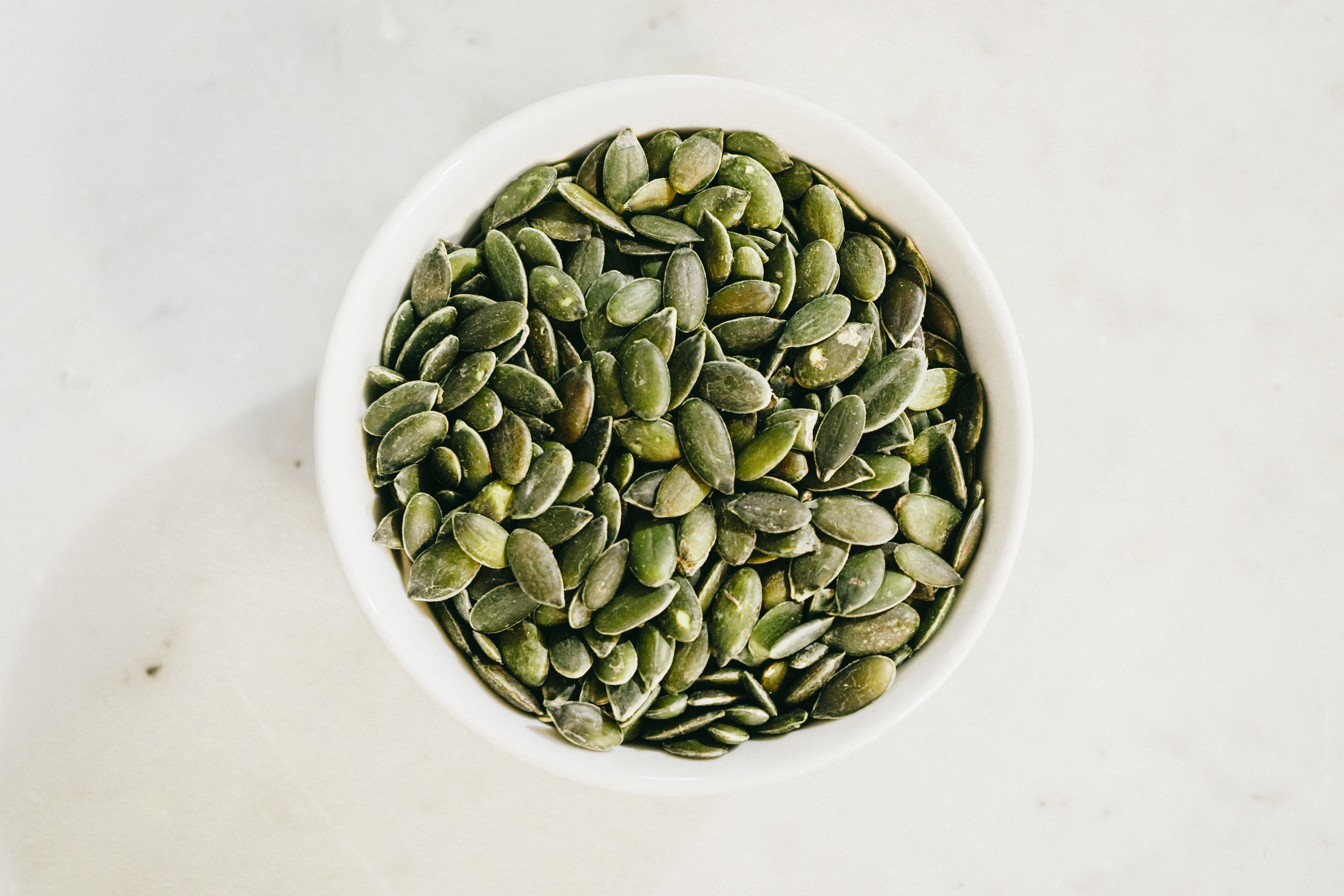 Bowl of raw shelled pumpkin seeds (pepitas)