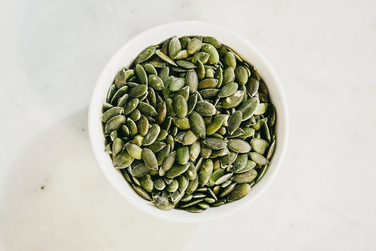 Bowl of raw shelled pumpkin seeds (pepitas)